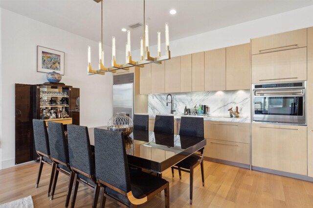 2200 Victory Ave Unit 2003, Dallas, TX 75219 - dining space with light wood finished floors, a chandelier, and recessed lighting
