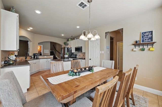 dining area with recessed lighting, an inviting chandelier, visible vents, arched walkways, and light tile patterned flooring