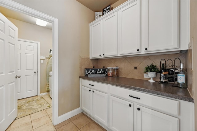 laundry room featuring baseboards and light tile patterned floors