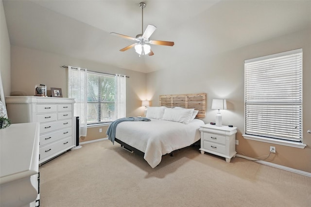 bedroom featuring ceiling fan, baseboards, and light colored carpet