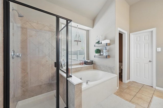 bathroom with a bath, tile patterned floors, a shower stall, and toilet