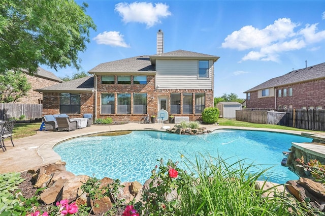 view of pool with a storage unit, a patio, and a fenced backyard