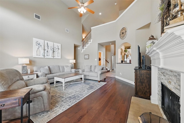 living area featuring visible vents, wood-type flooring, a fireplace, high vaulted ceiling, and ceiling fan