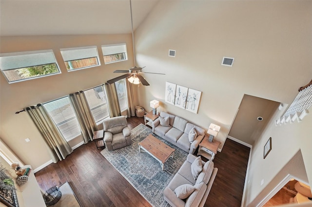 living room featuring wood finished floors, visible vents, baseboards, high vaulted ceiling, and ceiling fan