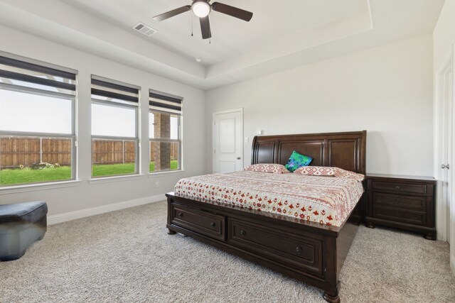 bedroom featuring light carpet, baseboards, visible vents, and multiple windows