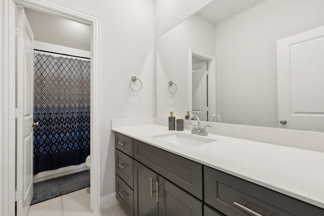 full bath with curtained shower, tile patterned flooring, toilet, vanity, and baseboards
