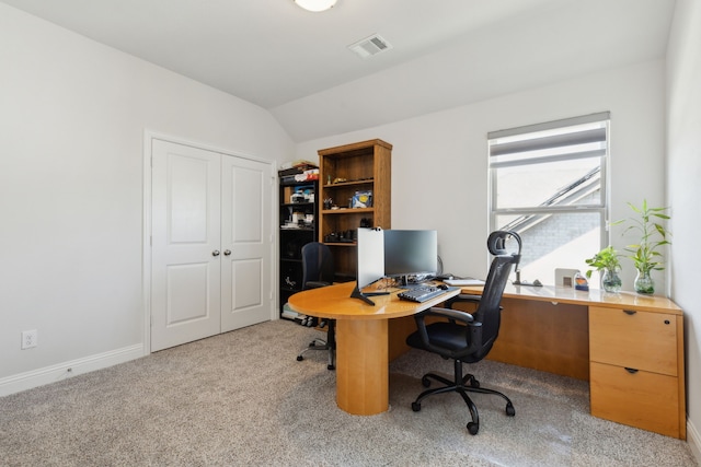 home office featuring baseboards, vaulted ceiling, visible vents, and light colored carpet