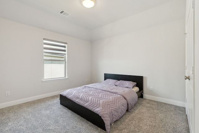 carpeted bedroom featuring baseboards, vaulted ceiling, and visible vents