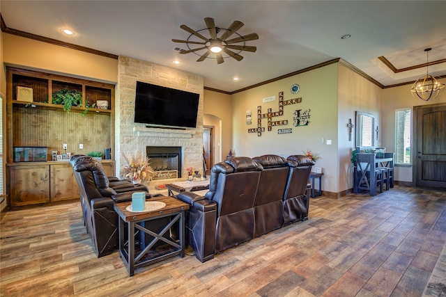living area featuring wood finished floors, a ceiling fan, and ornamental molding