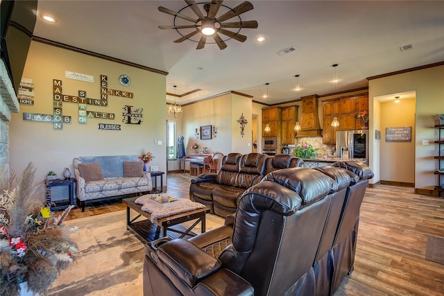 living room with ceiling fan with notable chandelier, light wood-style flooring, ornamental molding, visible vents, and recessed lighting