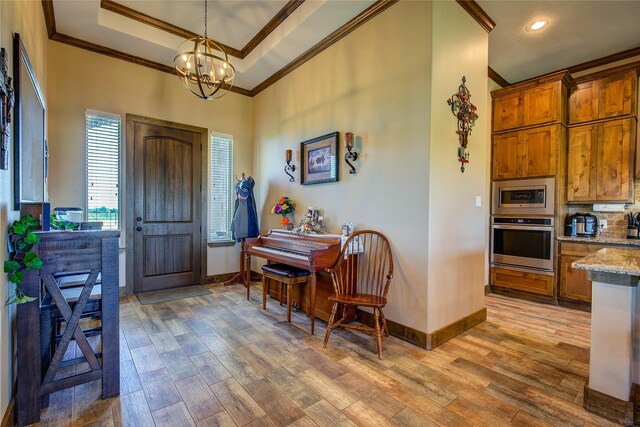 entryway with baseboards, ornamental molding, and wood finished floors