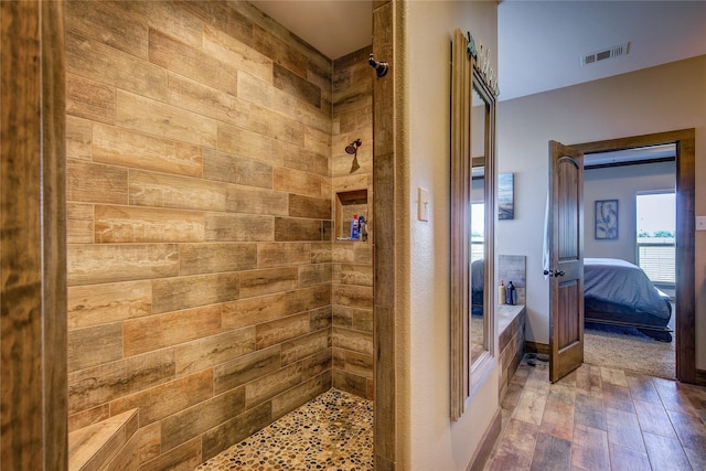 ensuite bathroom featuring wood finished floors, ensuite bath, tiled shower, and visible vents