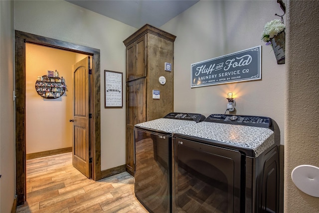 laundry area featuring baseboards, washer and clothes dryer, and light wood-style flooring