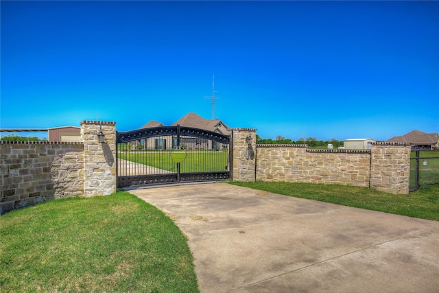 view of gate with a lawn and fence