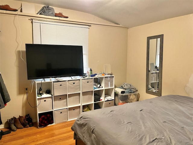 bedroom with vaulted ceiling and wood finished floors