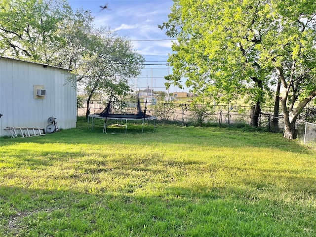 view of yard with fence and a trampoline