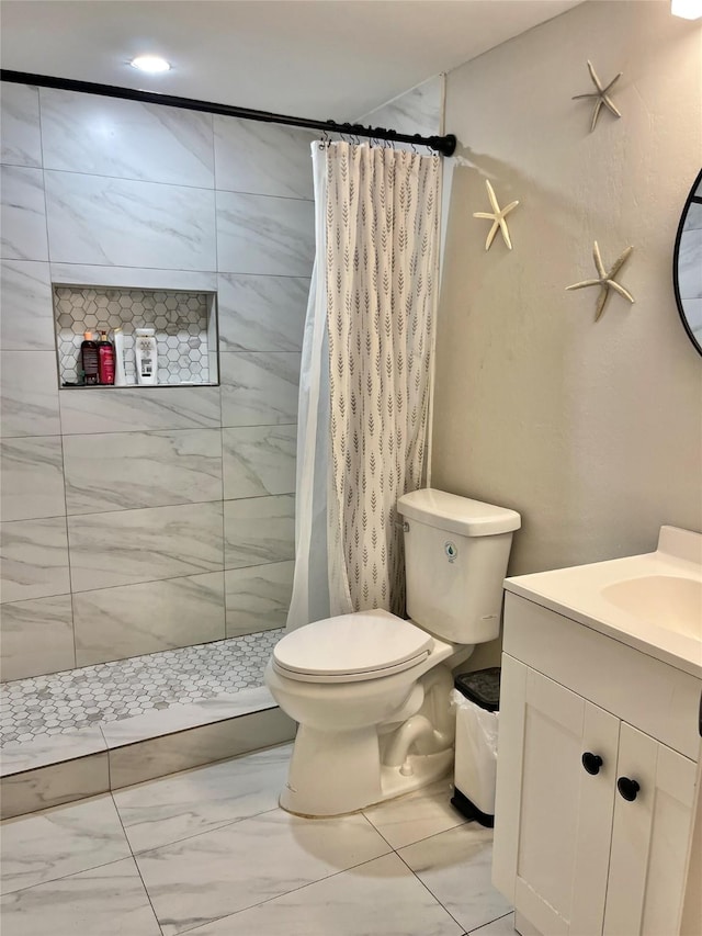 bathroom with marble finish floor, a tile shower, toilet, and vanity
