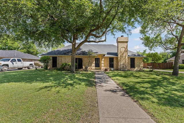single story home featuring fence, a shingled roof, a front lawn, and a chimney