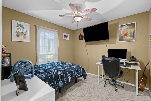 carpeted bedroom with ceiling fan and baseboards