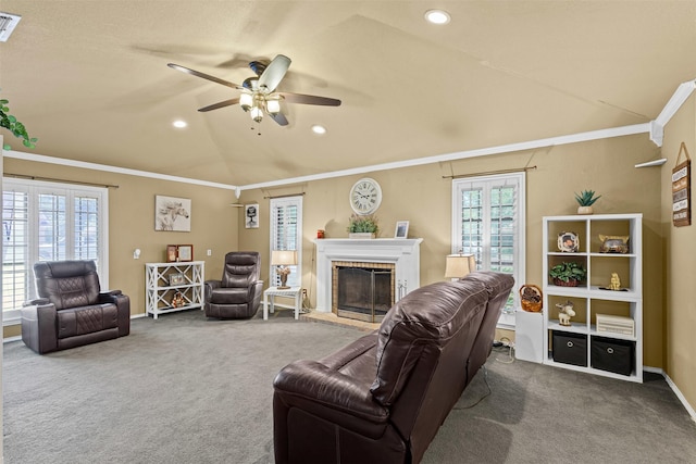 carpeted living area featuring vaulted ceiling, recessed lighting, a brick fireplace, ceiling fan, and ornamental molding