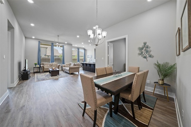 dining area featuring a chandelier, wood finished floors, baseboards, and recessed lighting