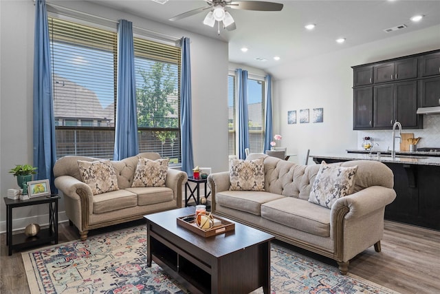 living room with recessed lighting, light wood-style floors, visible vents, and a ceiling fan