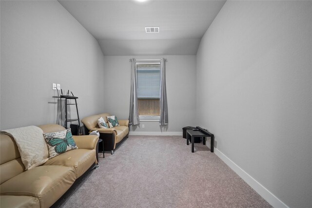 living area featuring baseboards, vaulted ceiling, visible vents, and carpet flooring