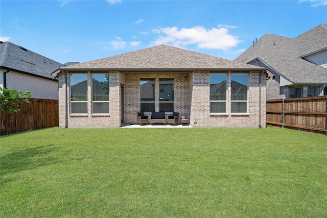 rear view of house with brick siding, an outdoor hangout area, a fenced backyard, and a yard