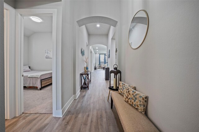 hallway with wood finished floors and arched walkways