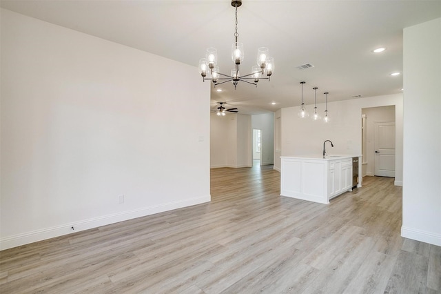 interior space featuring a sink, light wood-type flooring, baseboards, visible vents, and recessed lighting