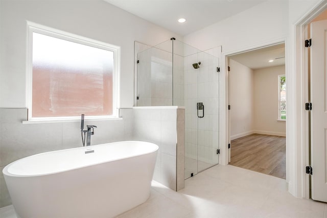 full bath with recessed lighting, a freestanding bath, and a stall shower