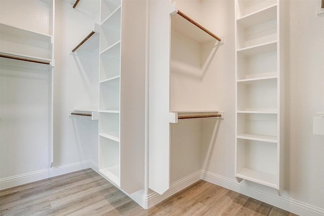 walk in closet with wood finished floors