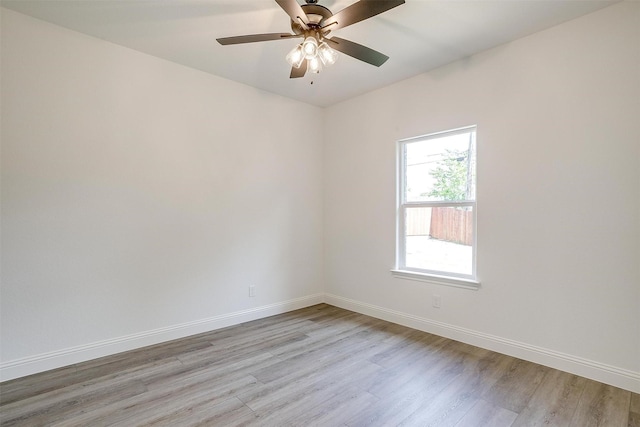 empty room with light wood-style flooring, a ceiling fan, and baseboards
