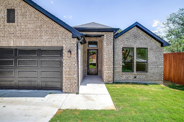 view of front of house featuring a front lawn, brick siding, fence, and a garage