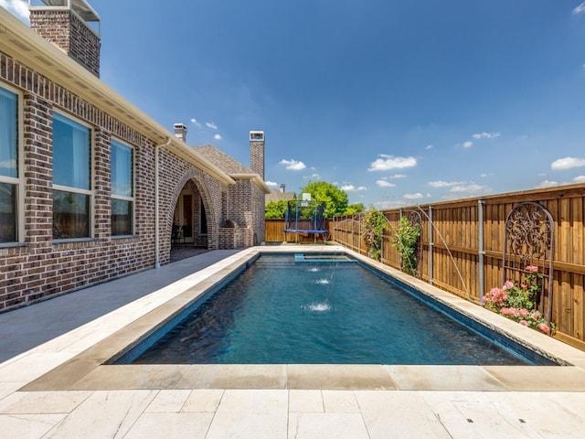 view of pool with a fenced in pool, a fenced backyard, and a trampoline