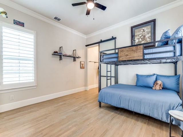 bedroom featuring visible vents, wood finished floors, multiple windows, and crown molding