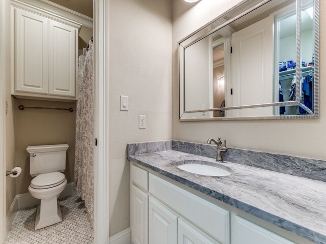 full bathroom with toilet, tile patterned flooring, vanity, and baseboards