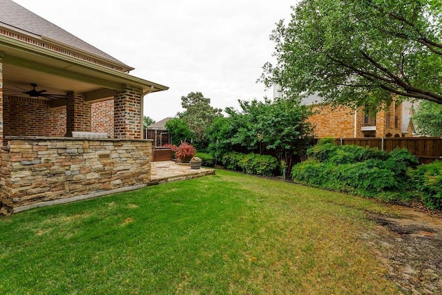 view of yard featuring fence, ceiling fan, and a patio area