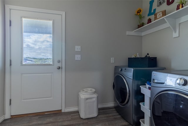 laundry area featuring separate washer and dryer, baseboards, wood finished floors, and laundry area