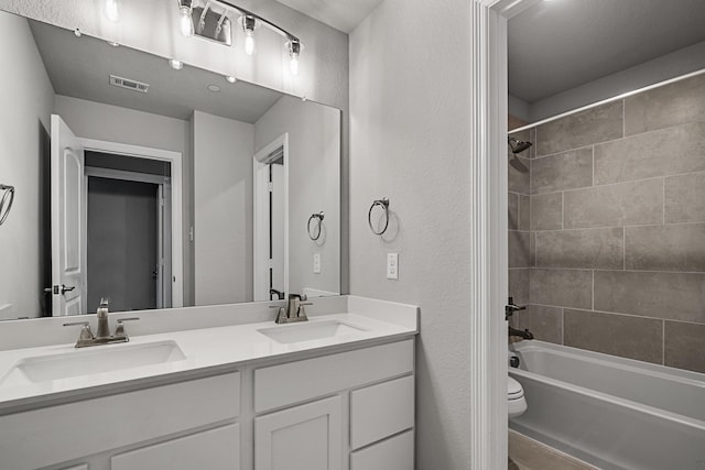 full bathroom with toilet, bathtub / shower combination, a sink, and double vanity