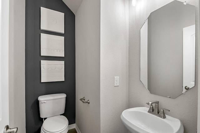 half bath featuring toilet and a sink
