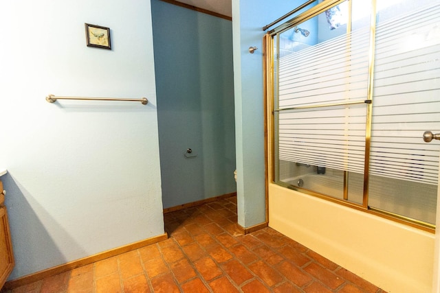 full bath with baseboards, shower / bath combination with glass door, and toilet