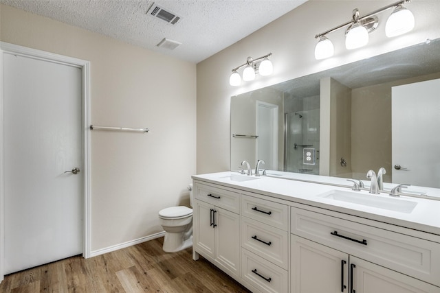 4504 Courtside Dr, Mckinney, TX 75070 - full bath featuring a shower stall, toilet, wood finished floors, a textured ceiling, and double vanity