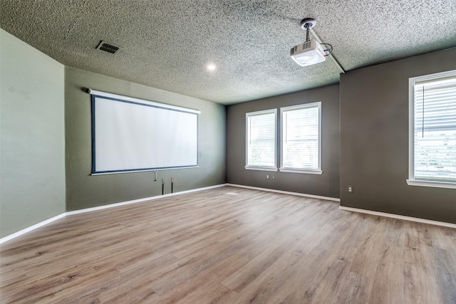 4504 Courtside Dr, Mckinney, TX 75070 - empty room featuring wood finished floors, healthy amount of natural light, a textured ceiling, and baseboards