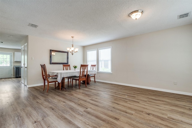 4504 Courtside Dr, Mckinney, TX 75070 - dining space with light wood-style floors, a chandelier, baseboards, and a textured ceiling