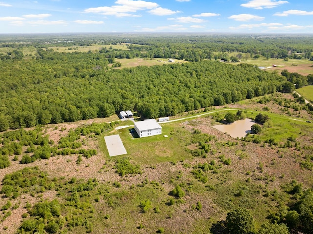 drone / aerial view with a wooded view and a water view