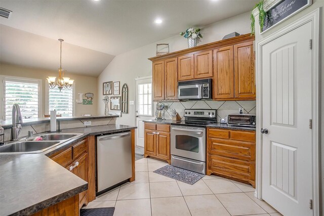 kitchen featuring a chandelier, dark countertops, appliances with stainless steel finishes, and a sink