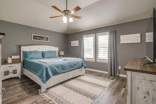 bedroom with a ceiling fan, baseboards, and dark wood-style flooring