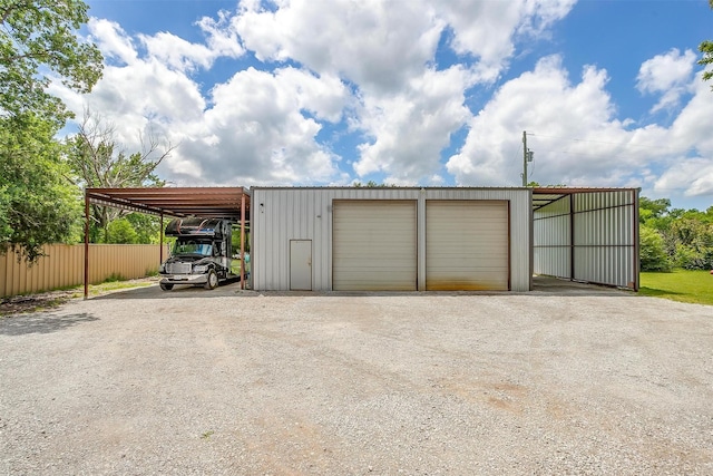 garage with fence and a detached garage