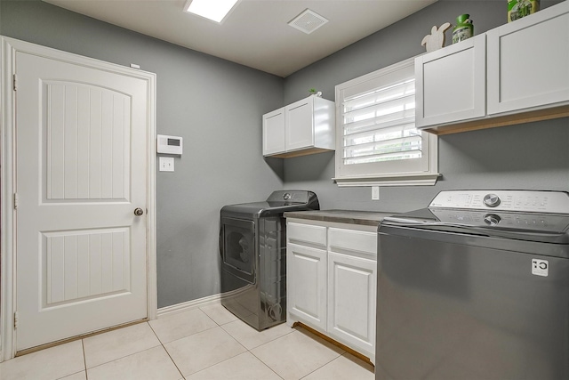 laundry room with washer and clothes dryer, baseboards, visible vents, cabinet space, and light tile patterned floors